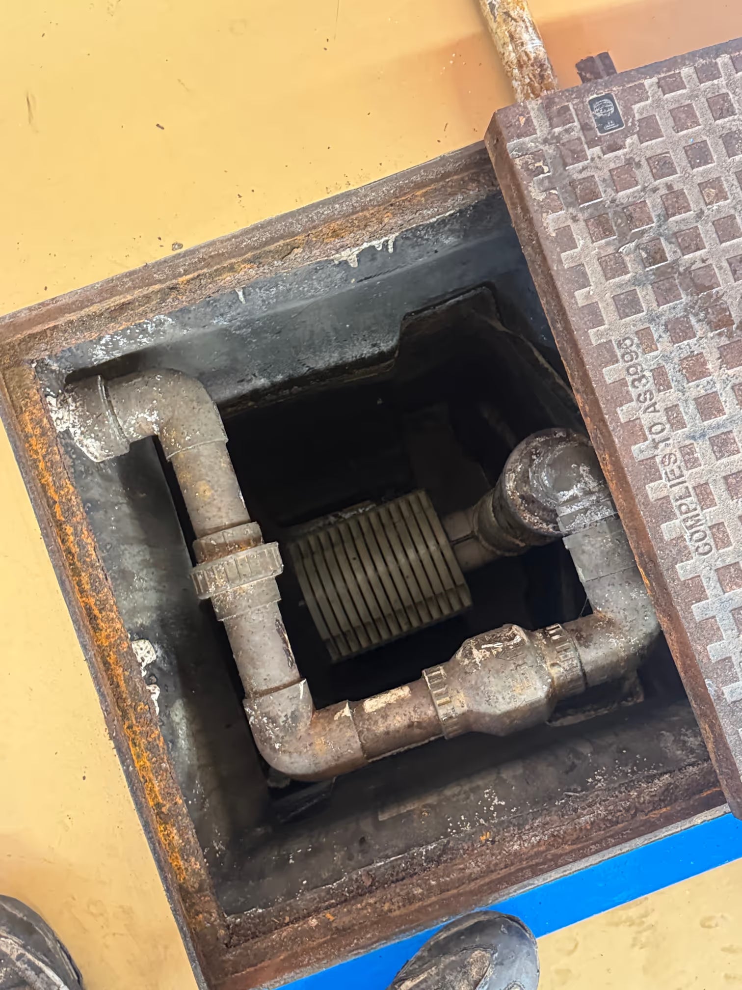 Technician performing a commercial grease trap pump out